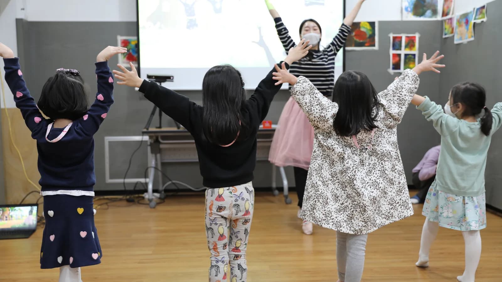 담임교사 한 명이 교실 앞에서 동작을 시범 보이고 아이들이 뒤에서 따라 하는 실제 수업 장면